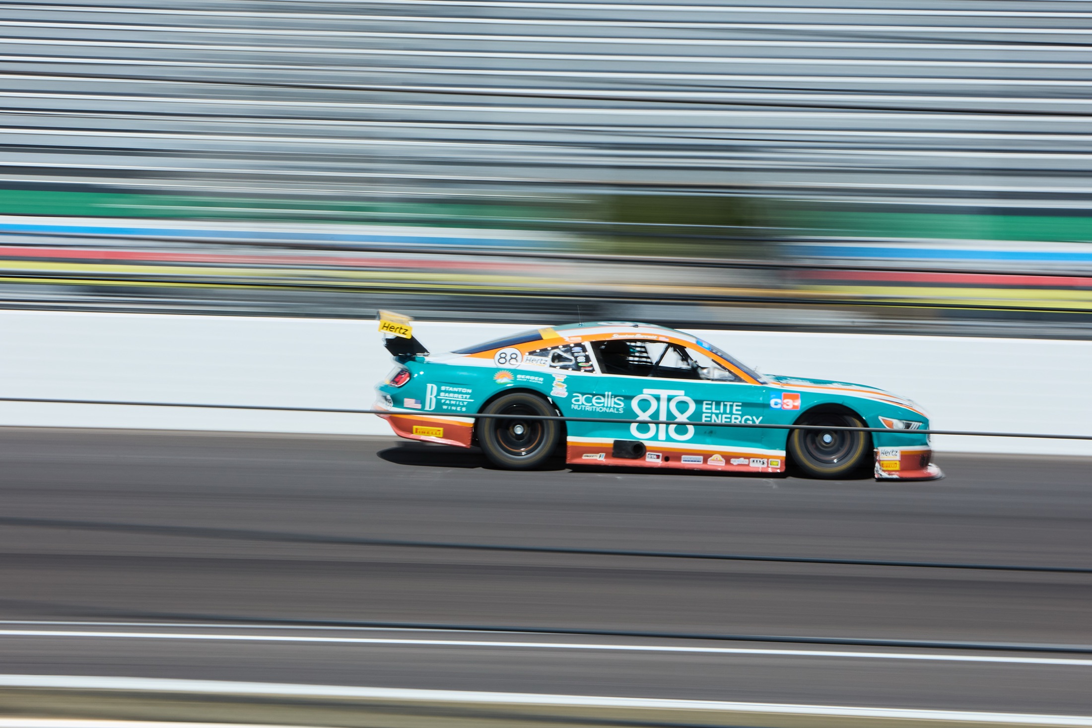 The Acellis 8T8 Ford Mustang at speed on a road course