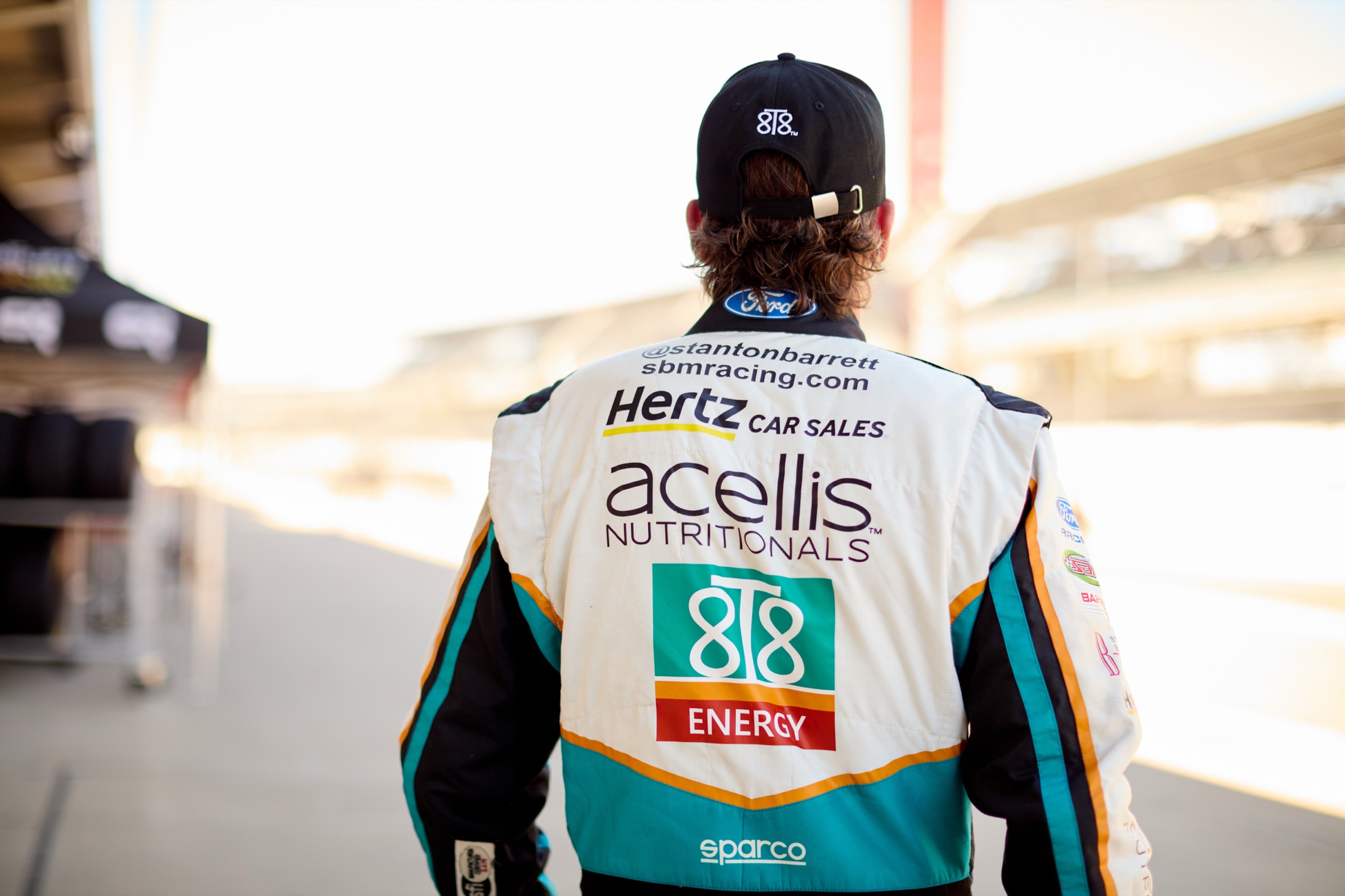 Stanton Barrett walking away down pit lane in his Acellis 8T8 firesuit